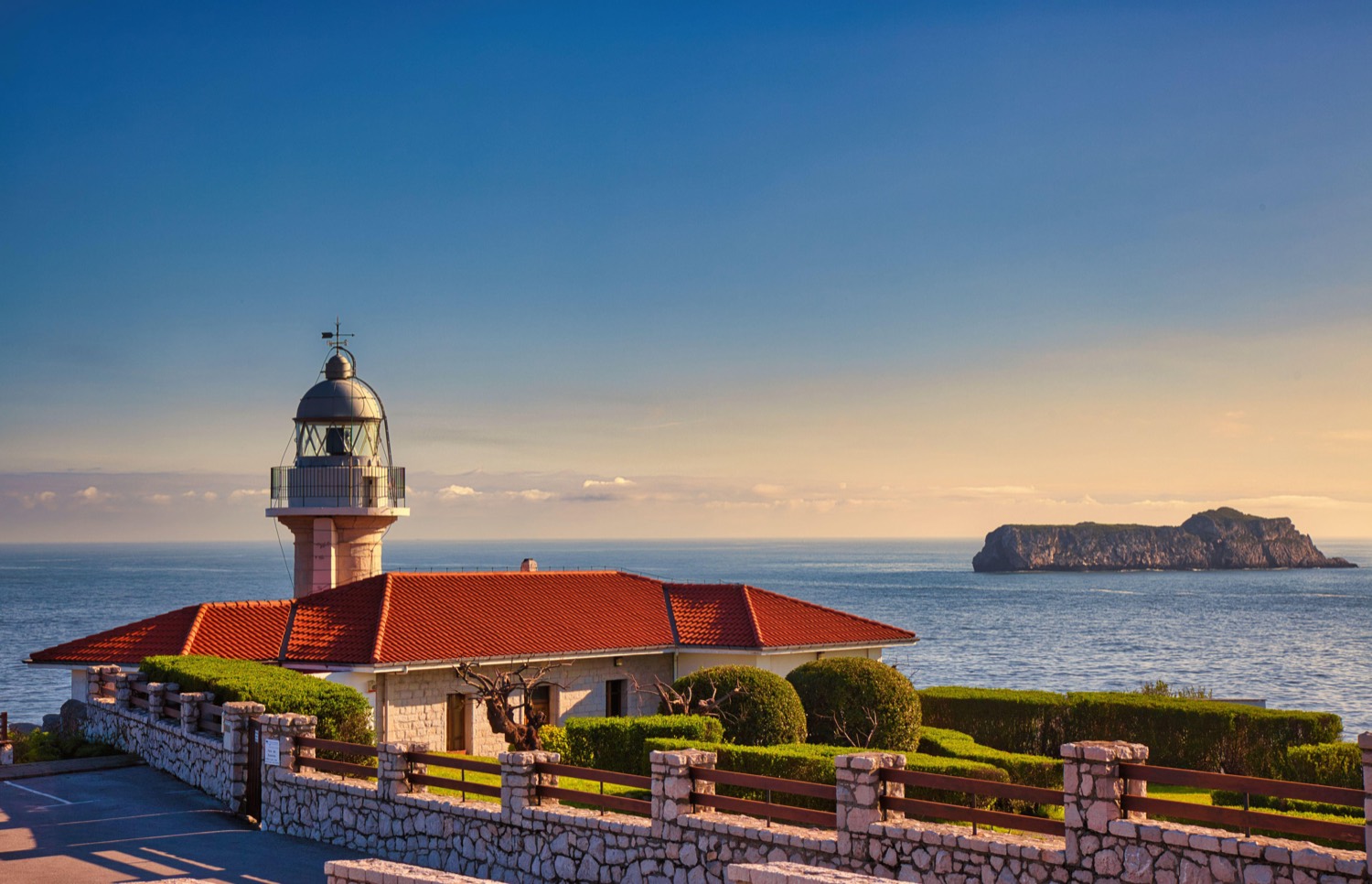 El faro de Suances al atardecer con la isla de los Conejos al fondo