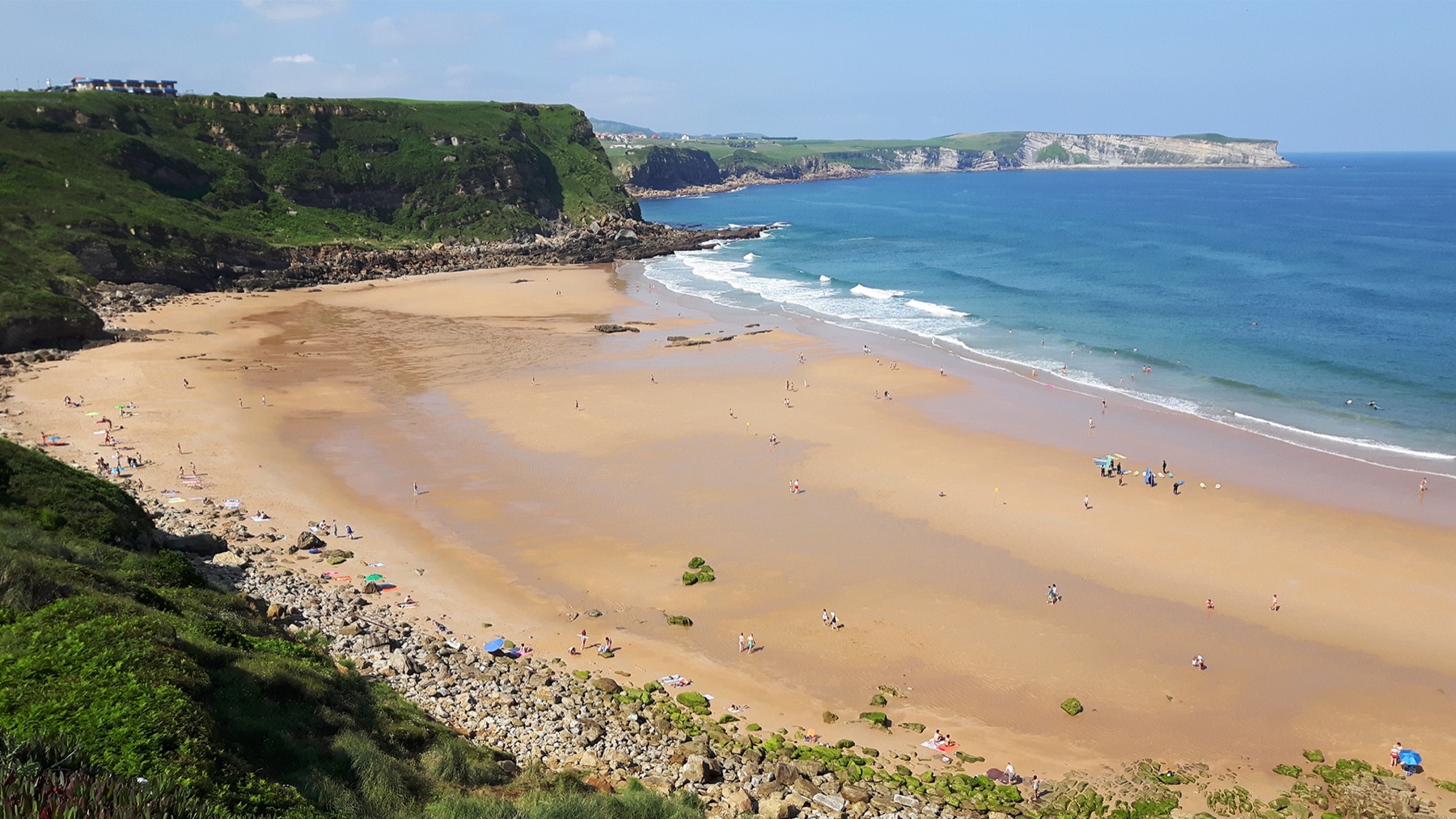 Playa de Los Locos, en Suances, con surfistas, desde el mirador