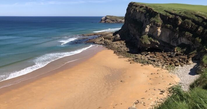 Playa de La Tablía en Suances, con acantilados, arena dorada y mar turquesa