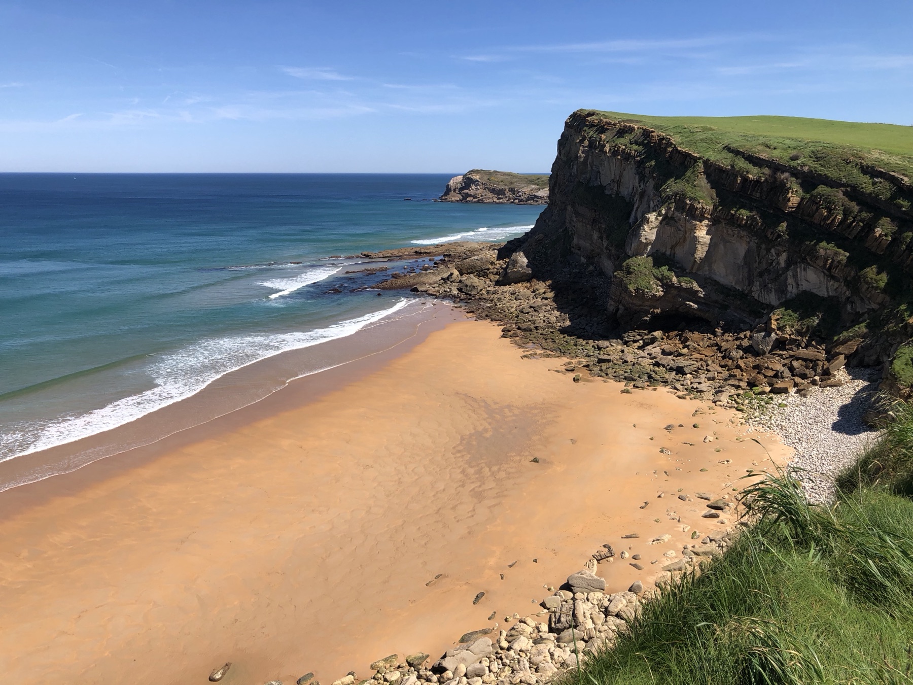 Playa de arena dorada y acantilados en la costa de Suances