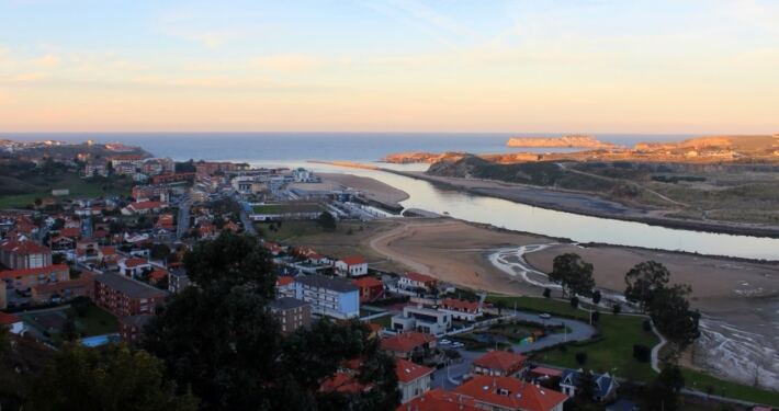 Vista de Suances al atardecer con sus tejados rojos y la ría